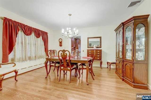 dining space featuring a chandelier, light wood-style flooring, a baseboard radiator, and baseboards