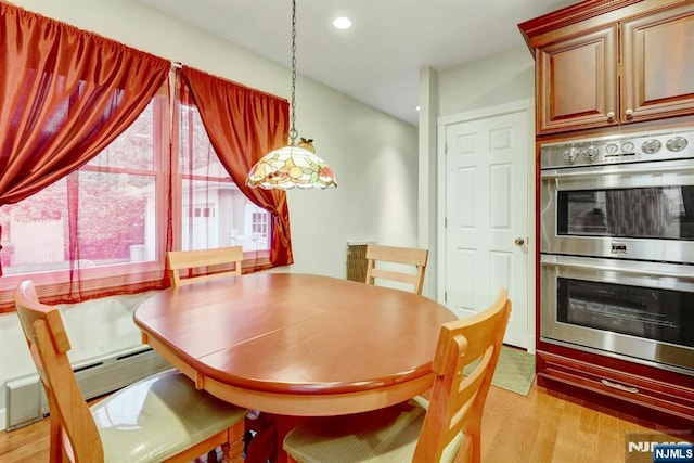 dining area with light wood-type flooring and recessed lighting