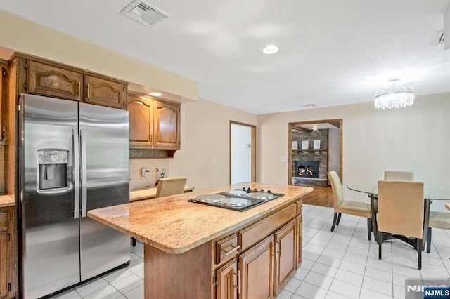 2 Morgan Ct, Montvale, NJ 07645 - kitchen with stainless steel fridge with ice dispenser, a fireplace, backsplash, a center island, and light tile patterned flooring