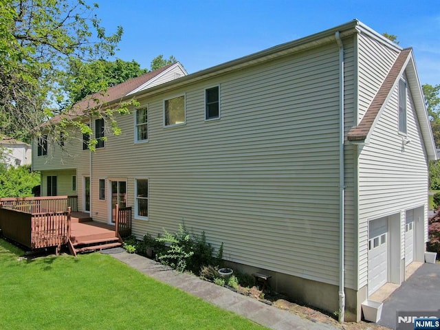 2 Morgan Ct, Montvale, NJ 07645 - back of property featuring a wooden deck, a lawn, and an attached garage
