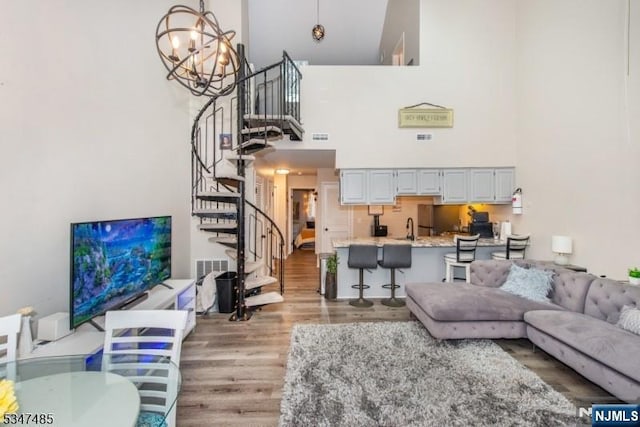 4 Winter Park Dr Unit 4, Vernon, NJ 07462 - living room featuring a towering ceiling, light wood-style floors, stairs, and a chandelier