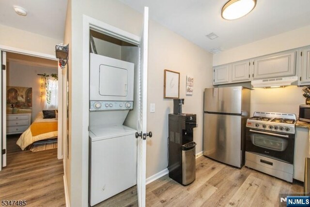 4 Winter Park Dr Unit 4, Vernon, NJ 07462 - kitchen featuring stainless steel appliances, stacked washing machine and dryer, under cabinet range hood, and light wood-style floors