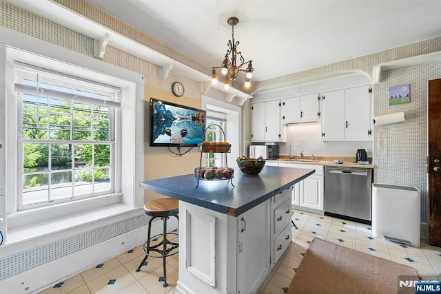 868 Goffle Rd, Hawthorne, NJ 07506 - kitchen featuring dishwasher, light tile patterned floors, white cabinetry, a chandelier, and dark countertops