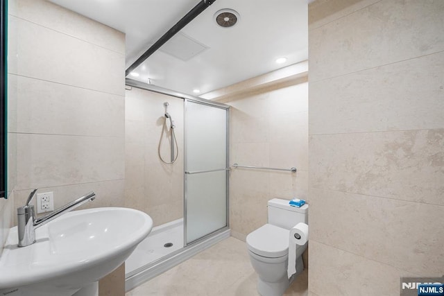 868 Goffle Rd, Hawthorne, NJ 07506 - bathroom featuring tile walls, a sink, a stall shower, toilet, and tile patterned floors