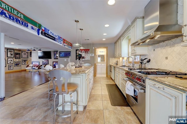 543 Page Ave, Lyndhurst, NJ 07071 - kitchen featuring stainless steel stove, wall chimney range hood, a sink, tasteful backsplash, and recessed lighting