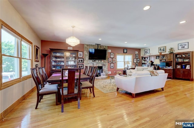 543 Page Ave, Lyndhurst, NJ 07071 - dining room with light wood-style flooring, a chandelier, a stone fireplace, recessed lighting, and baseboards