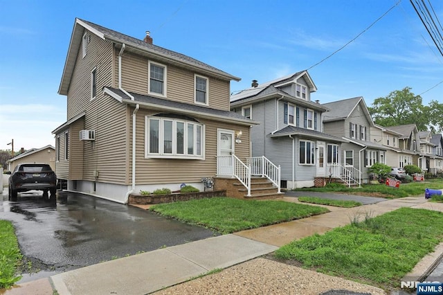 american foursquare style home with a residential view and an AC wall unit