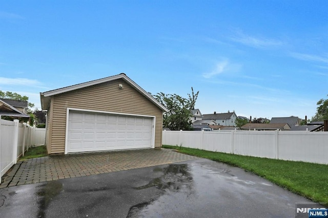 detached garage featuring fence