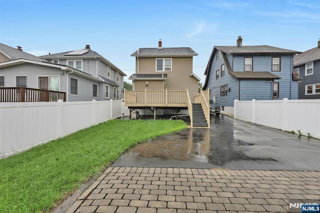 back of property featuring a residential view, stairway, and a deck