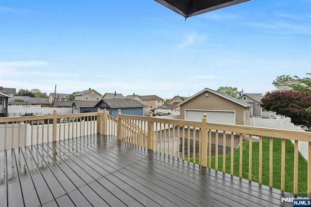 wooden deck featuring a residential view, an outdoor structure, and a garage