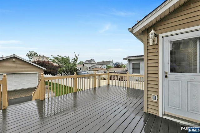 wooden deck featuring an outdoor structure, a residential view, and a garage