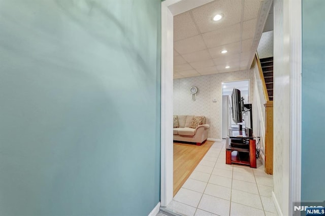 hall with recessed lighting, a paneled ceiling, light tile patterned floors, and wallpapered walls