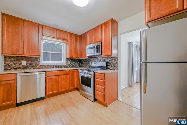 38 Pitcairn Ave, Ho-Ho-Kus, NJ 07423 - kitchen with appliances with stainless steel finishes, light wood-type flooring, tasteful backsplash, and a sink