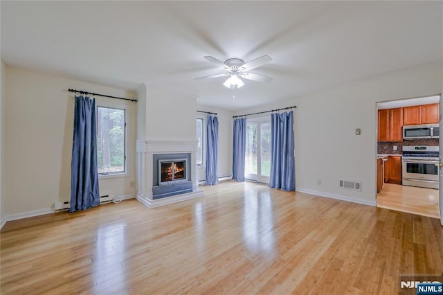 38 Pitcairn Ave, Ho-Ho-Kus, NJ 07423 - unfurnished living room with a ceiling fan, light wood finished floors, a warm lit fireplace, and baseboards