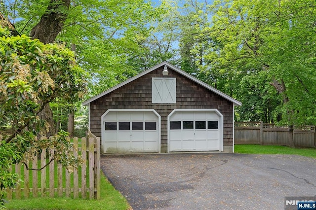 detached garage featuring fence