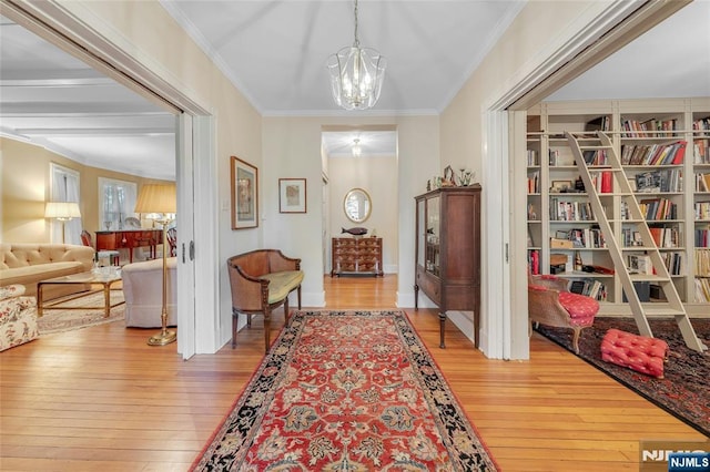 foyer with hardwood / wood-style flooring, a chandelier, and crown molding