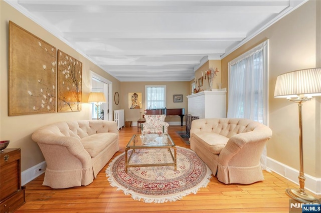 living area with radiator, beamed ceiling, hardwood / wood-style floors, and baseboards