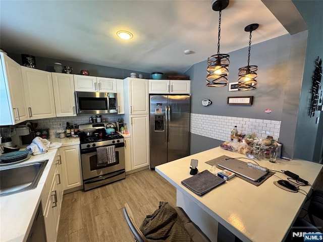 717 1st St, Lyndhurst, NJ 07071 - kitchen featuring stainless steel appliances, decorative backsplash, light wood-style floors, white cabinets, and light countertops