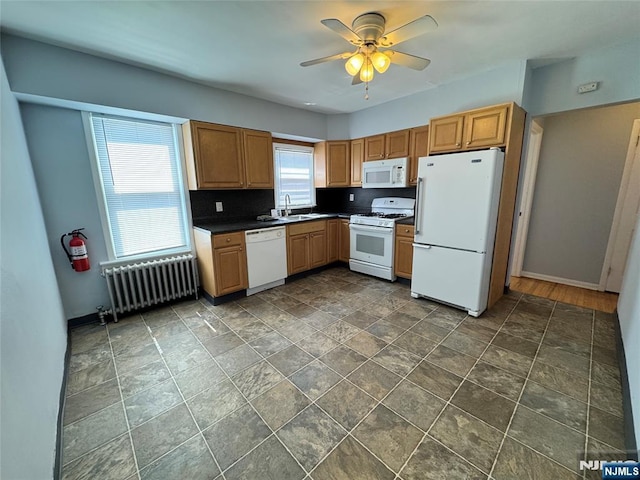 717 1st St, Lyndhurst, NJ 07071 - kitchen featuring radiator, white appliances, a sink, ceiling fan, and dark stone finish flooring
