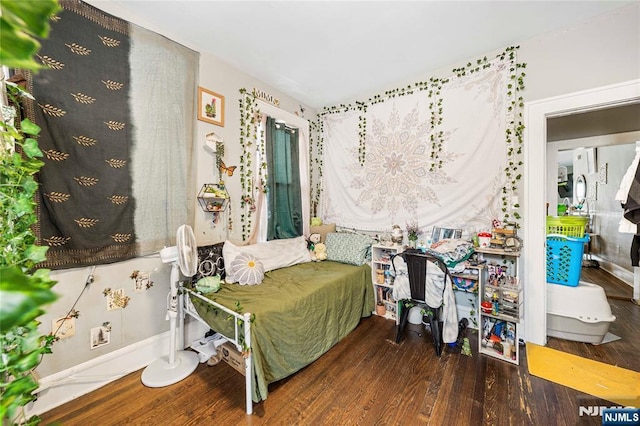 bedroom with wood finished floors and baseboards