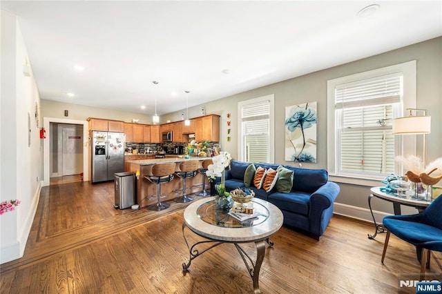 living area featuring baseboards, plenty of natural light, dark wood-style floors, and recessed lighting