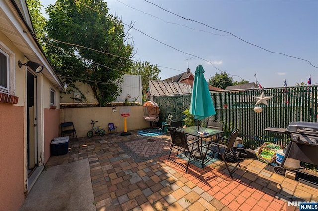 view of patio with a fenced backyard, outdoor dining area, and a grill