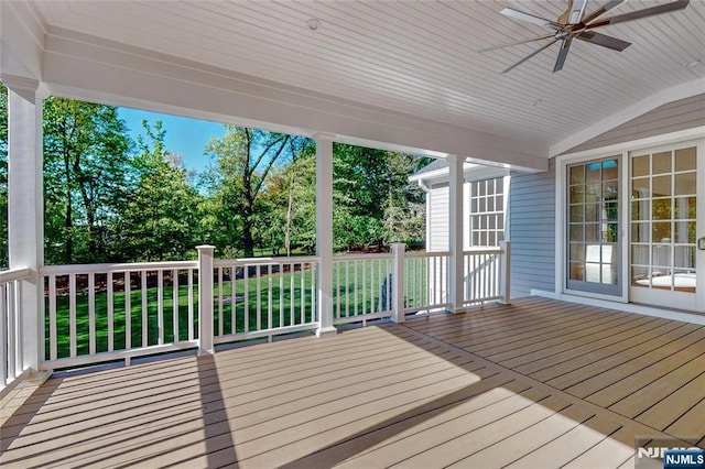 wooden terrace with ceiling fan and view of wooded area