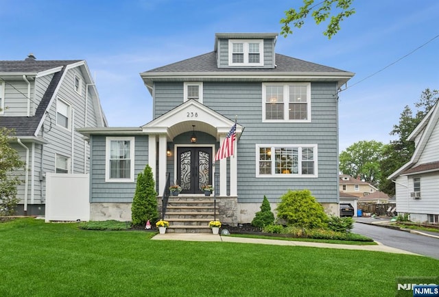 american foursquare style home featuring a front lawn, french doors, and a shingled roof