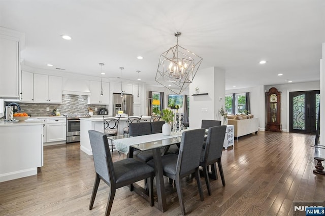 dining space featuring a chandelier, wood finished floors, and recessed lighting