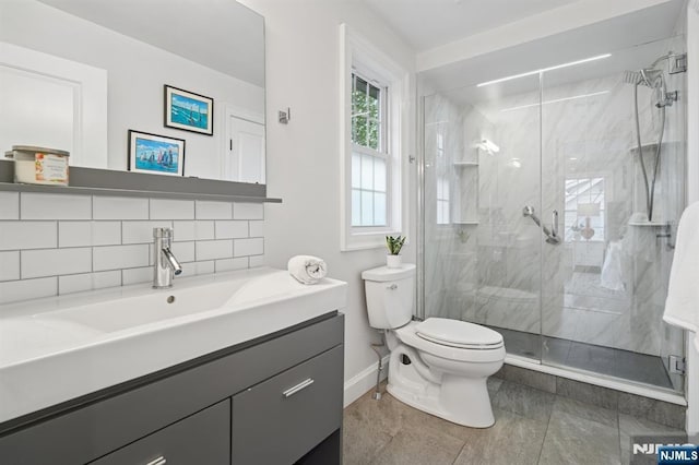 full bath featuring toilet, baseboards, a stall shower, and vanity