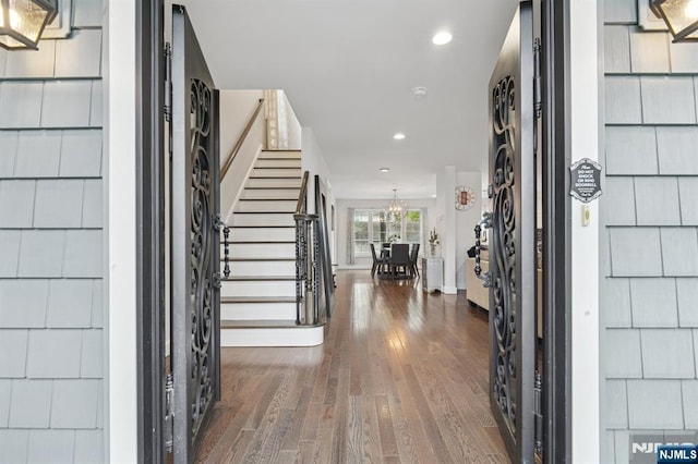foyer entrance with wood-type flooring, stairway, and recessed lighting