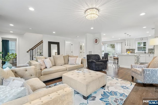living room with wood finished floors, recessed lighting, a chandelier, stairs, and baseboards