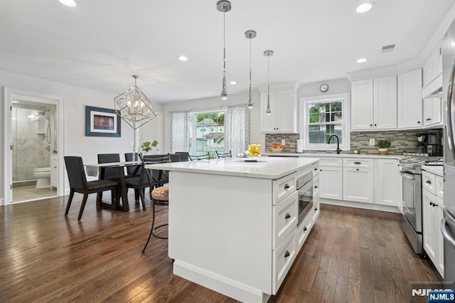 kitchen with stainless steel appliances, healthy amount of natural light, a center island, tasteful backsplash, and recessed lighting