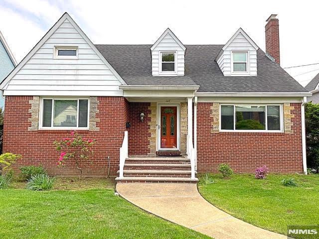 107 Virginia Ave, Clifton, NJ 07012 - view of front of property featuring brick siding, a chimney, a front lawn, and a shingled roof