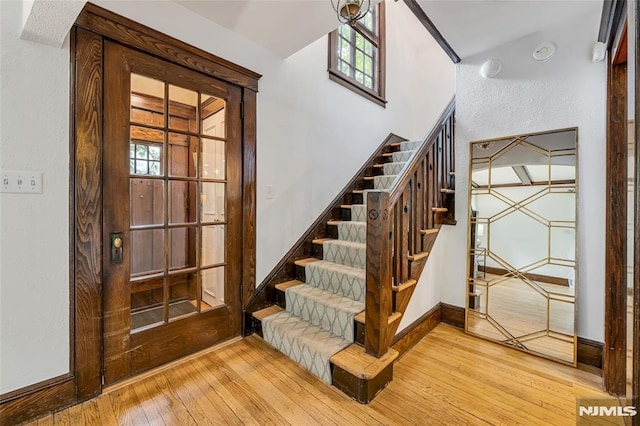 stairs with hardwood / wood-style flooring, healthy amount of natural light, and baseboards