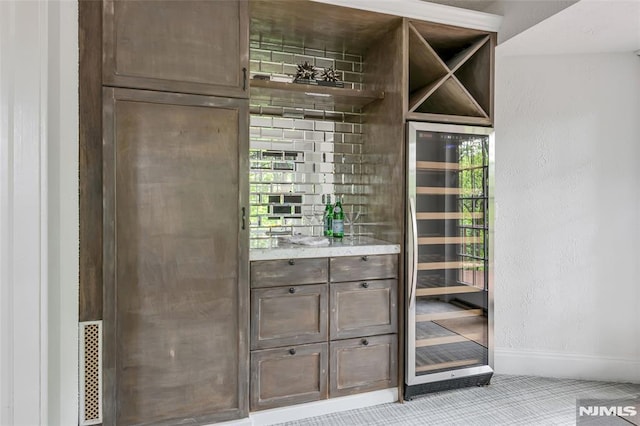 bar with wine cooler, baseboards, and light carpet