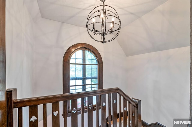 stairs with a chandelier and lofted ceiling