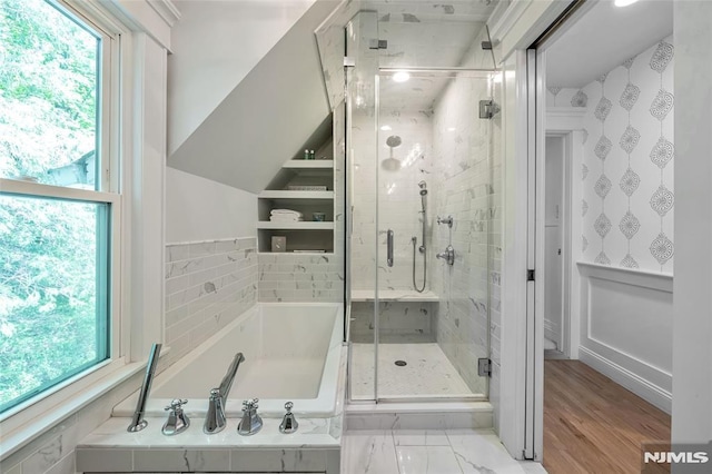 bathroom with a bath, a stall shower, and healthy amount of natural light