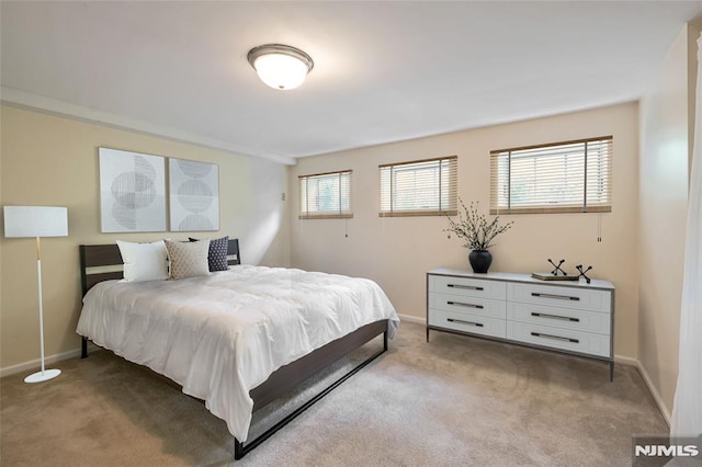 bedroom with light carpet and baseboards