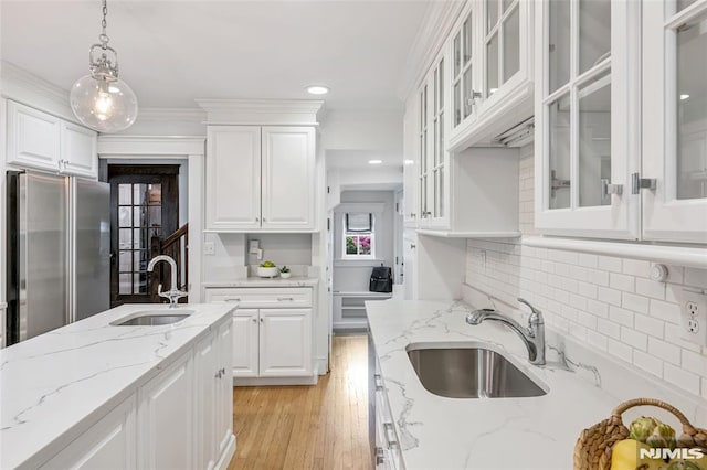 kitchen with a sink, white cabinets, decorative light fixtures, backsplash, and recessed lighting
