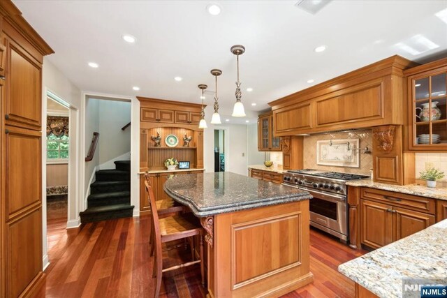 15 Hamilton Rd, Morristown Town, NJ 07960 - kitchen with double oven range, brown cabinetry, a center island, backsplash, and dark wood-style floors