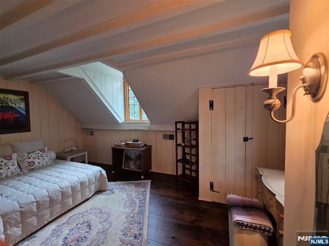 bedroom featuring dark wood finished floors and wooden walls