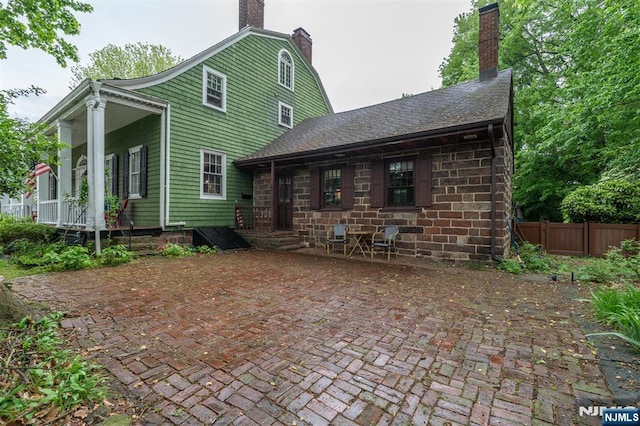 back of house with a chimney