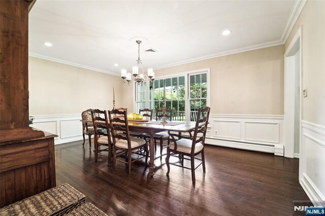 dining space featuring a baseboard heating unit, a chandelier, crown molding, dark wood-type flooring, and wainscoting