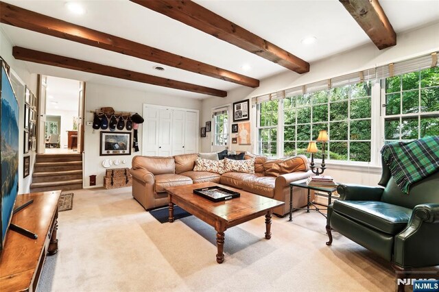 living area featuring beam ceiling, plenty of natural light, light carpet, and recessed lighting