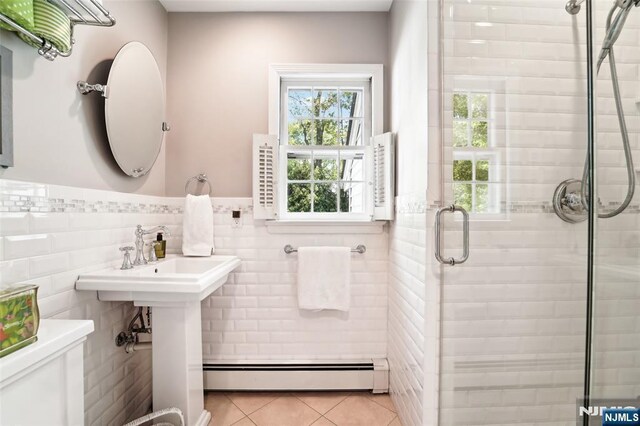 full bathroom with a baseboard heating unit, tile patterned floors, a stall shower, tile walls, and healthy amount of natural light