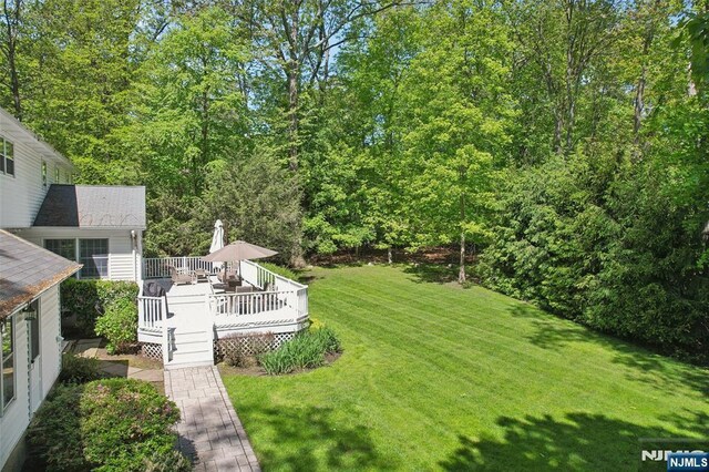 view of grassy yard featuring a wooden deck