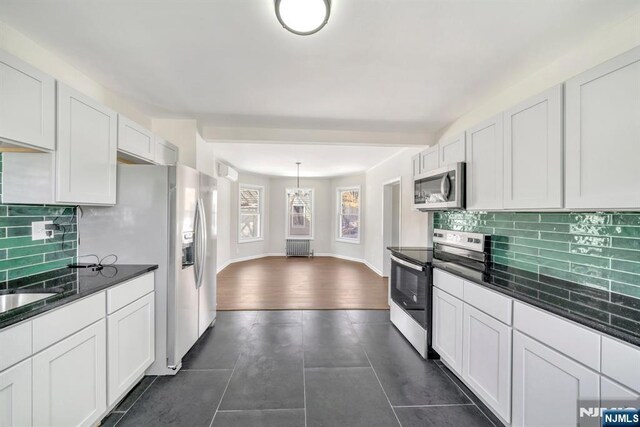 14 Harvard Ave, Wyckoff, NJ 07481 - kitchen with stainless steel appliances, backsplash, white cabinetry, and dark tile patterned flooring