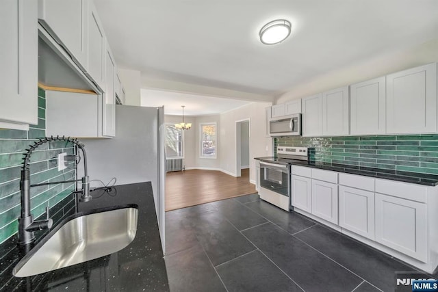 14 Harvard Ave, Wyckoff, NJ 07481 - kitchen featuring stainless steel appliances, a sink, dark countertops, tasteful backsplash, and a chandelier