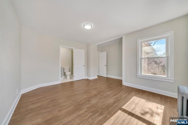14 Harvard Ave, Wyckoff, NJ 07481 - unfurnished bedroom featuring wood finished floors, baseboards, ensuite bath, and radiator heating unit